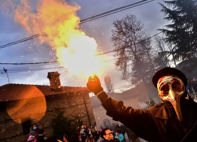 Costumed people take part on the first day of a carnival celebration marking the Orthodox St. Vasilij Day in the village of Vevcani, Republic of North Macedonia, 13 January 2021. The Vevcani Carnival is one of the most famous village festivals in the Balkans. It is believed that the custom is over 1,400 years old and based on old pagan beliefs. Essentially the carnival is the ritual of calling after Saint Basil the Great, which coincides with the Twelve Days of the Orthodox Christmas and the Orthodox New Year. The festivity is held on 13 and 14 January every year. People in Vevcanci believe that with their masks they banish evil spirits. The participants of the carnival are known as Vasilicari. The highlights of the carnival include a political satire where masked villagers act out current events. In 1993, the carnival and the village of Vevcani officially became a part of the World Federation of Carnival Cities. (Photo by Nake Batev/EPA/EFE)