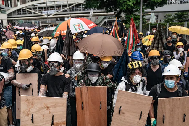 Anti-extradition protesters use makeshift shield to defend themselves during a clash with police outside the Legislative Council Complex ahead of the annual flag raising ceremony of 22nd anniversary of the city's handover from Britain to China on July 1, 2019 in Hong Kong, China. Thousands of pro-democracy protesters faced off with riot police on Monday during the 22nd anniversary of Hong Kongs return to Chinese rule as riot police officers used batons and pepper spray to push back demonstrators. The citys embattled leader Carrie Lam watched a flag-raising ceremony on a video display from inside a convention centre, citing bad weather, as water-filled barricades were set up around the exhibition centre. (Photo by Anthony Kwan/Getty Images)