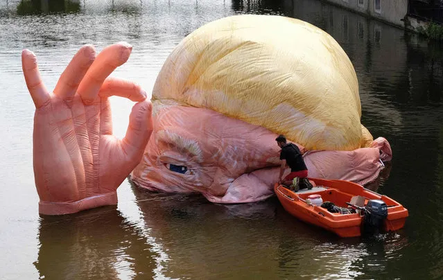 A picture taken on July 5, 2019 shows the installation “Everything is fine” depicting the half submerged head of US President Donald Trump by Jacques Rival, architect, displayed in the Moselle river as part of the digital art festival “Constellations de Metz” in Metz, eastern France. “Constellations de Metz” is a digital arts festival that runs from June 20 to September 7, 2019 and focuses on showcasing the area’s urban spaces and heritage. (Photo by Jean-Christophe Verhaegen/AFP Photo)