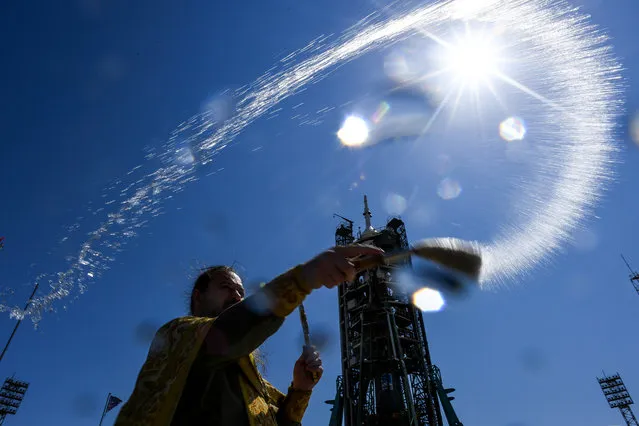 A Russian Orthodox priest blesses the Soyuz MS-13 spacecraft at the launch pad of the Russian-leased Baikonur cosmodrome on July 19, 2019. Members of the International Space Station (ISS) expedition 60/61, NASA astronaut Andrew Morgan, Russian cosmonaut Alexander Skvortsov and Italian astronaut Luca Parmitano of ESA (European Space Agency), are preparing for the launch aboard the Soyuz MS-13 spacecraft on July 20, 2019. (Photo by Kirill Kudryavtsev/AFP Photo)