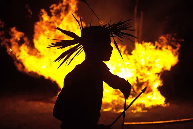 In this Monday, June 10, 2019 photo, an Indian Rabha tribal Hindu priest dances around burning charcoal as part of rituals during Baikho festival at Pantan village, west of Gauhati, India. Every year, the community in India’s northeastern state of Assam celebrates the festival, to please a deity of wealth and ask for good rains and a good harvest. (Photo by Anupam Nath/AP Photo)