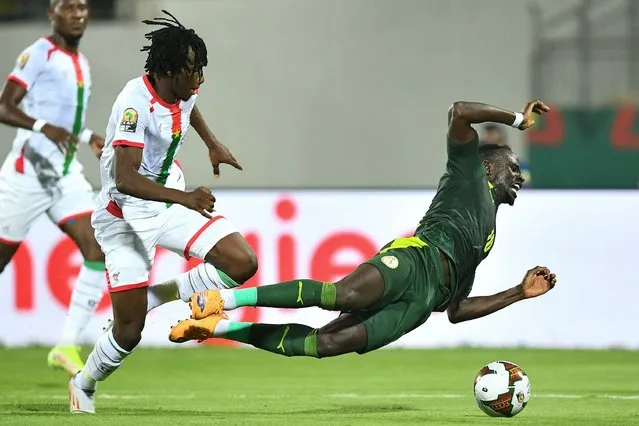 Burkina Faso's defender Issa Kabore (L) challenges Senegal's forward Sadio Mane during the Africa Cup of Nations (CAN) 2021 semi final football match between Burkina Faso and Senegal at Stade Ahmadou-Ahidjo in Yaounde on February 2, 2022. (Photo by Charly Triballeau/AFP Photo)