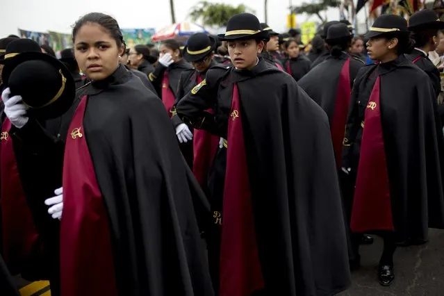 Students gather after marching in a parade celebrating Saint Peter's day in Lima, Peru, Monday, June 29, 2015. (Photo by Rodrigo Abd/AP Photo)
