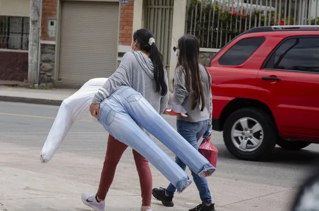 Artisans sell life-size dolls made of cardboard and sawdust in Cuenca, Ecuador on December 31, 2021. These dolls usually represent important people, politicians, movie characters or important events of the passing year and are burned at a family or friends party on December 31 saying goodbye to the negative things of the passing year and welcoming a new and better year. (Photo by Dario Ordonez/Anadolu Agency via Getty Images)