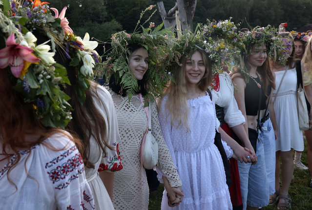 Participants dance during the celebration of the Pagan holiday of Ivan Kupala, a traditional holiday that has been observed in Ukraine since pre-Christian times, in Kyiv, on June 23, 2024, amid the Russian invasion in Ukraine. (Photo by Anatolii Stepanov/AFP Phoot)