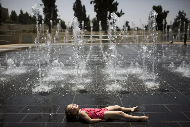 An Israeli child plays in a water fountain on a hot day near the Tower of David in the Old City of Jerusalem, Israel, 15 May 2016. According to the Israeli Metereological Service, an intense heatwave has hit the country, with temperatures as high as 44 degrees Celsius expected in some areas. (Photo by Abir Sultan/EPA)