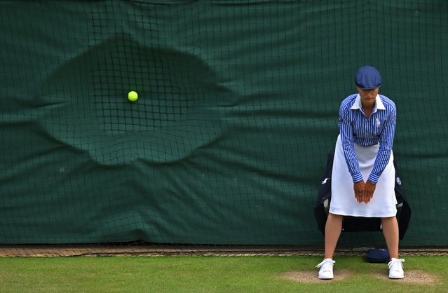 A line judge stands in position as a ball hits the back netting after a serve during the men's doubles semi-final tennis match between Britain's Henry Patten and Finland's Harri Heliövaara, and New Zealand's Michael Venus and Britain's Neal Skupski, on the eleventh day of the 2024 Wimbledon Championships at The All England Lawn Tennis and Croquet Club in Wimbledon, southwest London, on July 11, 2024. (Photo by Andrej Isakovic/AFP Photo)