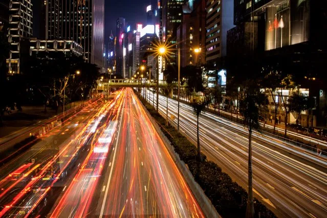This picture taken using a slow shutter speed shows motorists driving along Gloucester Road in the Wanchai district in Hong Kong on October 10, 2019. (Photo by Mohd Rasfan/AFP Photo)