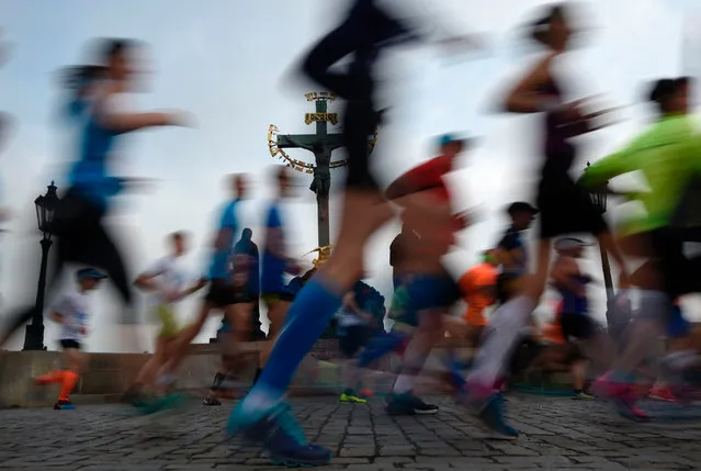 Athletes cross the Charles Bridge as they compete in the Prague Marathon in on May 7, 2017. (Photo by Michal Cizek/AFP Photo)