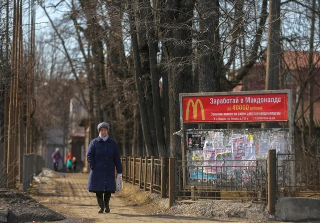 A woman walks along a street past a banner offering job at McDonald's in the town of Pokrov in Vladimir Region, Russia on March 21, 2022. (Photo by Evgenia Novozhenina/Reuters)