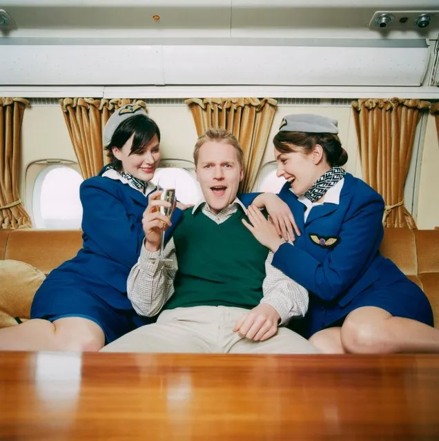 Man with flight attendants. (Photo by Richard Kolker/Getty Images)