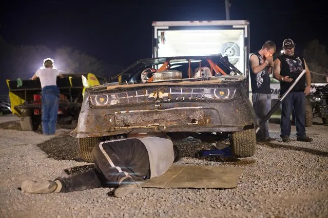 In this July 17, 2015 photo, Glen Hounshell fixes tie rods in his car, which had broken during dirt track racing at the Ponderosa Speedway in Junction City, Ky. Hounshell's steering had broken during a qualifying round and he had to get it fixed before the main race. (Photo by David Stephenson/AP Photo)