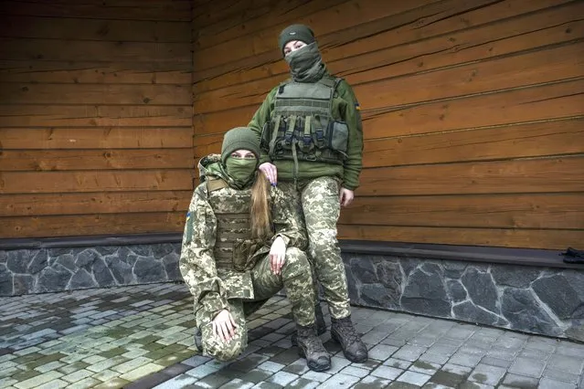 Territorial Defense of the Armed Forces, 21-year-olds Svitlana, right, and Myroslava, pose for a photograph, in Lviv, western Ukraine, Thursday, March 31, 2022. Both Svitlana, and Myroslava, who studied at the same university in Kyiv, decided to leave academia and serve their country by joining the TDF only one month ago. (Photo by Nariman El-Mofty/AP Photo)