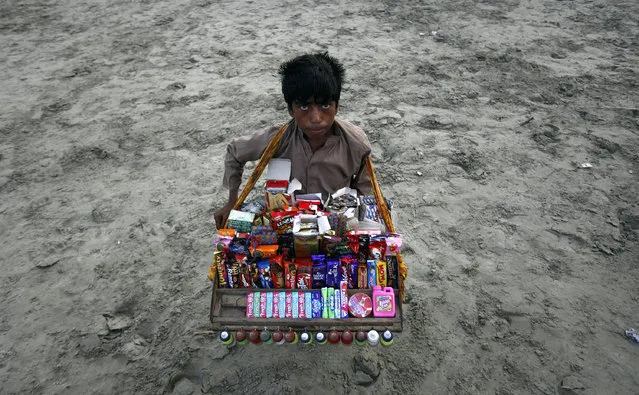 Ali Jan, 13, sells biscuits and sweets at Karachi's Clifton beach July 10, 2011. (Photo by Athar Hussain/Reuters)