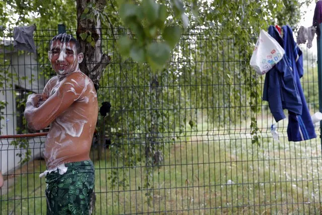 A migrant from Afghanistan washes himself in an improvised shelter outside a brick factory in Subotica, Serbia July 27, 2015. (Photo by Laszlo Balogh/Reuters)