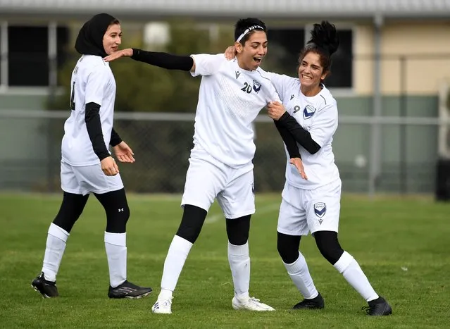 Melbourne Victory Afghan womens team player Manozh (C) and teammates celebrate a goal which was disallowed during their first match in a local league against ETA Buffalo SC in Melbourne on April 24, 2022. Players from Afghanistan's national women's football team competed in a local league match in Australia on April 24 for the first time since fleeing the hardline Islamist Taliban. (Photo by William West/AFP Photo)