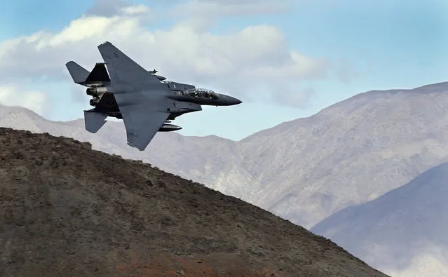 In this February 27, 2017, photo an F-15E Strike Eagle from Seymour Johnson AFB in North Carolina flies out of the nicknamed Star Wars Canyon turning toward the Panamint range over Death Valley National Park, Calif. Military jets roaring over national parks have long drawn complaints from hikers and campers. But in California's Death Valley, the low-flying combat aircraft skillfully zipping between the craggy landscape has become a popular attraction in the 3.3 million acre park in the Mojave Desert, 260 miles east of Los Angeles. (Photo by Ben Margot/AP Photo)