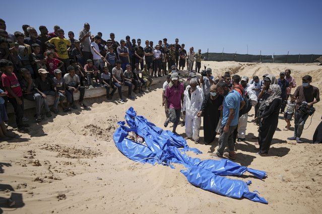 Workers bury bodies returned by Israel in a cemetery in Khan Younis, Gaza Strip, Monday, August 5, 2024. A Palestinian official says Israel has returned more than 80 bodies to the Gaza Strip. The identities of the deceased and the cause of death were not immediately known. (Photo by Abdel Kareem Hana/AP Photo)