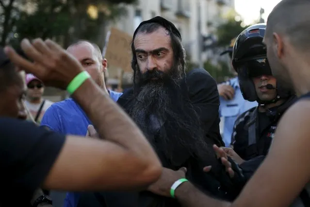 People detain after disarming an Orthodox Jewish assailant, after he stabbed and injured six participants of an annual gay pride parade in Jerusalem on Thursday, police and witnesses said July 30, 2015. (Photo by Amir Cohen/Reuters)