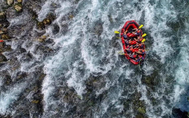 People do rafting on a rubber inflatable boat through the faster rapids at Koprucay of Koprulu Canyon in Manavgat district of Antalya, Turkey on August 29, 2019. Antalya, the capital of tourism, which attracts tourists from all over of the world with its sea, sun, beaches, history and culture, also offers rafting for guests seeking for adventure and adrenaline. Rafting is a preferred outdoor activity at Koprucay in Koprulu Canyon National Park. Despite the scorching heat of the city, the rafting season started by rowing with inflatable boats in the cold waters flowing from the highlands. (Photo by Mustafa Ciftci/Anadolu Agency via Getty Images)