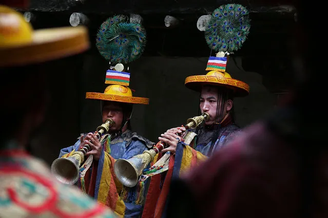 Buddhist monks play gyaling, traditional Tibetan horns, while performing a ceremony in the former King's palace during the Tenchi Festival on May 25, 2014 in Lo Manthang, Nepal. The Tenchi Festival takes place annually in Lo Manthang, the capital of Upper Mustang and the former Tibetan Kingdom of Lo. Each spring, monks perform ceremonies, rites, and dances during the Tenchi Festival to dispel evils and demons from the former kingdom. (Photo by Taylor Weidman/Getty Images)
