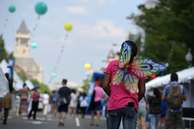 A DC Pride Festival goer walks down Pennsylvania Ave. sporting butterfly wings June 12, 2016 in Washington, DC. (Photo by Katherine Frey/The Washington Post)