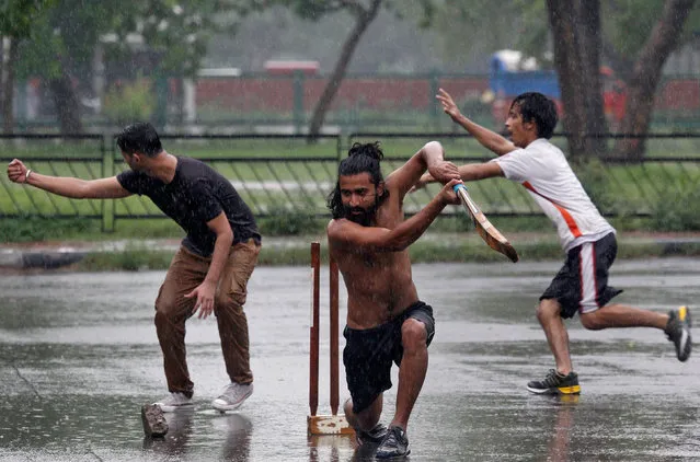 Boys play cricket at a parking lot as it rains in Chandigarh, India, July 11, 2017. (Photo by Ajay Verma/Reuters)