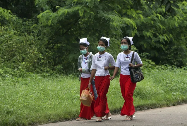 Nurses walk wearing masks to protect themselves form the swine flu virus outside the Naypyitaw Hospital Tuesday, July 25, 2017, in Naypyitaw, Myanmar. Public health officials in Myanmar say that H1N1 flu, also known as swine flu, has killed three people out of 13 confirmed cases of the infection. (Photo by Aung Shine Oo/AP Photo)
