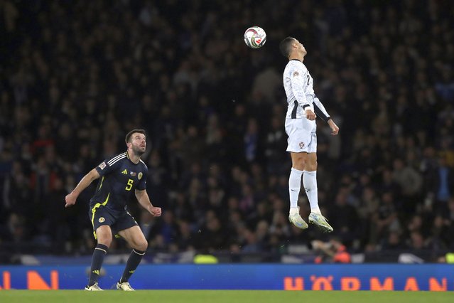 Portugal's Cristiano Ronaldo, right, heads the ball ahead of Scotland's Grant Hanley during the UEFA Nations League soccer match between Scotland and Portugal at Hampden Park in Glasgow, Scotland, Tuesday, October 15, 2024. (Photo by Scott Heppell/AP Photo)