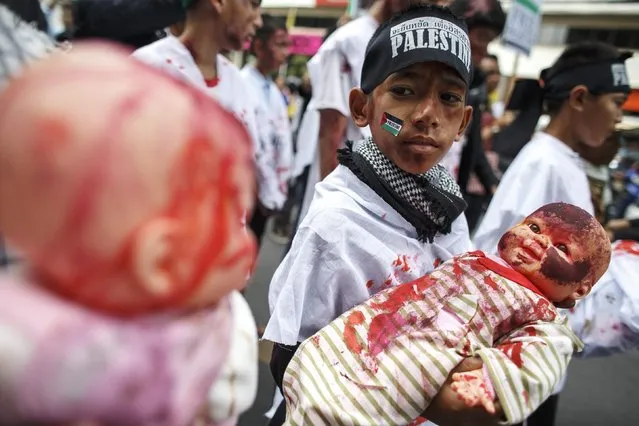 Demonstrators hold dolls, with make-up of injuries,  during an anti-Israel protest in front of the Israeli embassy, in Bangkok July 25, 2014. Gazan authorities said Israeli forces shelled a shelter at a U.N.-run school on Thursday, killing at least 15 people as the Palestinian death toll in the conflict climbed over 760 and attempts at a truce remained elusive. The Israeli military said it was investigating the incident. (Photo by Athit Perawongmetha/Reuters)