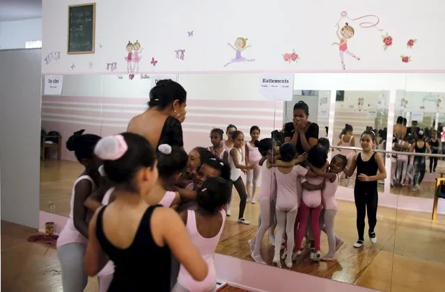 Young girls embrace their teacher Joana de Assis after their ballet lesson at the House of Dreams dance school in the Luz neighborhood known to locals as Cracolandia (Crackland) in Sao Paulo, Brazil, August 12, 2015. (Photo by Nacho Doce/Reuters)