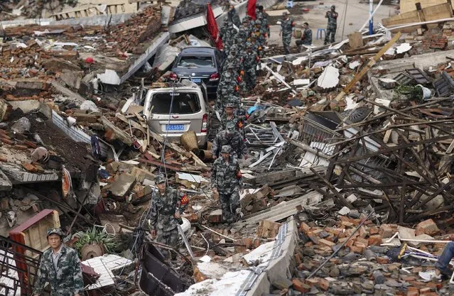 Rescuers search for survivors as they walk among debris of collapsed buildings after an earthquake hit Longtoushan township of Ludian county, Yunnan province August 4, 2014. A magnitude 6.3 earthquake struck southwestern China on Sunday, killing at least 398 people in a remote area of Yunnan province, and causing thousands of buildings, including a school, to collapse. (Photo by Wong Campion/Reuters)