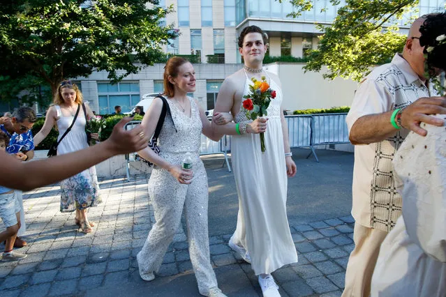 Couples arrive to a mass wedding for covid-delayed couples at Lincoln Center in New York City on July 10, 2022. (Photo by Kena Betancur/AFP Photo)