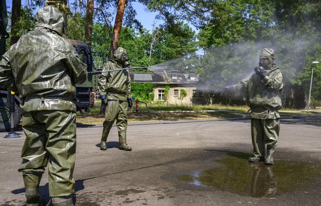 Members of the “ABC-Abwehrregiment 1” of the German Armed Forces (Bundeswehr) simulate decontamination procedures at their headquarters in Strausberg, near Berlin, eastern Germany, on July 20, 2022. The Defense Regiment “ABC-Abwehrregiment 1” of the German Armed Forces (Bundeswehr) was officially commissioned on April 6, 2022 to support all military organizational units of the Bundeswehr in the defense against nuclear, biological, chemical threads and industrial hazardous materials and provides decontamination. (Photo by John MacDougall/AFP Photo)