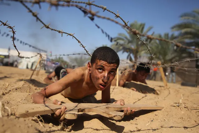 A Palestinian boy takes part in a military-style summer camp being held by the Islamic Jihad movement during the youngsters' summer school vacation in Khan Younes town, in the southern Gaza Strip, 13 July 2016. Thousands of youngsters between the age of six and 16 can participate in the summer camp where they receive military as well as religious training. (Photo by Hatem Omar/EPA)