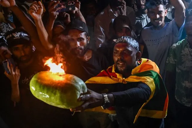 Demonstrators take part in a celebration as Sri Lanka's protest movement reached its 100th day at the Galle face protest area near Presidential secretariat in Colombo on July 17, 2022. (Photo by Arun Sankar/AFP Photo)