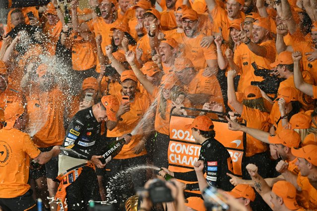 McLaren's British driver Lando Norris and McLaren's Australian driver Oscar Piastri celebrate with their team after winning the Abu Dhabi Formula One Grand Prix at the Yas Marina Circuit in Abu Dhabi on December 8, 2024. (Photo by Andrej Isakovic/AFP Photo)