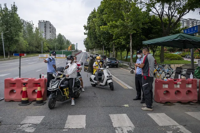 This photo taken on September 1, 2022 shows police officers checking information on a road amid restrictions due to an outbreak of the Covid-19 coronavirus in Chengdu, in China's southwestern Sichuan province. (Photo by CNS/AFP Photo)