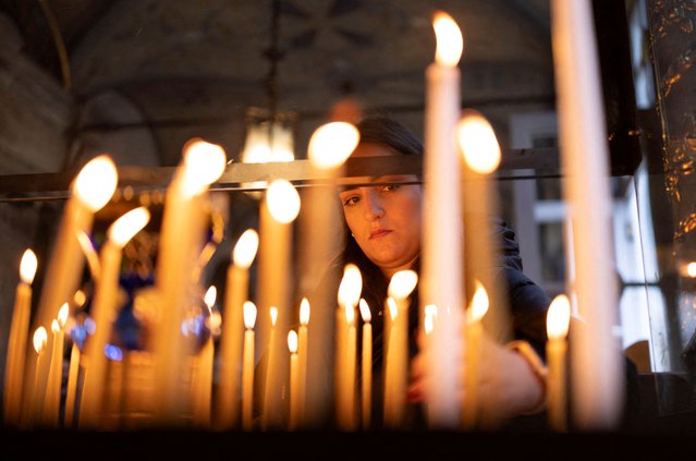 A Greek Orthodox worshipper lights candles as people arrive for an Epiphany Service at the Patriarchal Church of St. George in Istanbul, Turkey, on January 6, 2025. (Photo by Umit Bektas/Reuters)