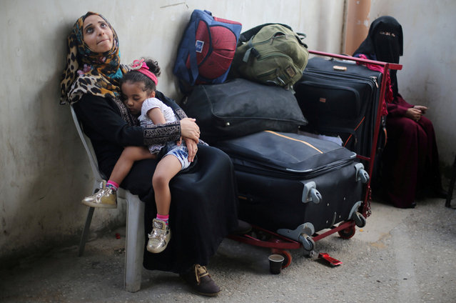 A Palestinian woman holds her daughter as they wait for a travel permit to cross into Egypt through the Rafah border crossing after it was opened by Egyptian authorities for humanitarian cases, in Rafah in the southern Gaza Strip August 16, 2017. (Photo by Ibraheem Abu Mustafa/Reuters)