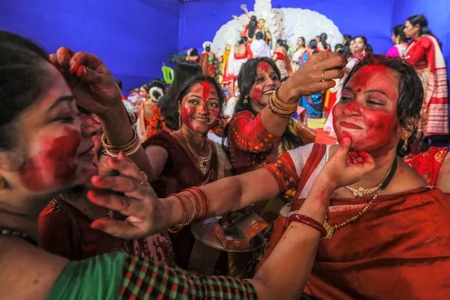 Indian women devotees of the Bengali community applying Sindoor or vermillion on each other's faces as they take part in the “Sindoor Puja”, a ritual before the immersion of Goddess Durga idols into water bodies on the last day of the Durga Puja Festival in Mumbai, India, 05 October 2022. Sindoor puja marks the end of Durga Puja Festival. The five day long Hindu festival Durga Puja is widely celebrated in the Indian states of West Bengal, Assam, Jharkhand, Orissa and Tripura and culminates in the immersion of the idols of Hindu Goddess Durga, who symbolizes power and the triumph of good over evil in Hindu mythology. (Photo by Divyakant Solanki/EPA/EFE/Rex Features/Shutterstock)