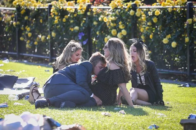 A young man nuzzles the breasts of a female companion as they sit on the grass on 2017 Derby Day at Flemington Racecourse on November 4, 2017 in Melbourne, Australia. (Photo by Splash News and Pictures)