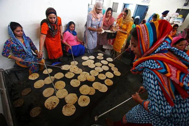 Devotees prepare “chapatis” (Indian bread) at a community kitchen in a Gurudwara or a Sikh temple on the occasion of the 548th birth anniversary of Guru Nanak Dev, the first Sikh Guru and founder of Sikh faith, in Chandigarh, November 4, 2017. (Photo by Ajay Verma/Reuters)