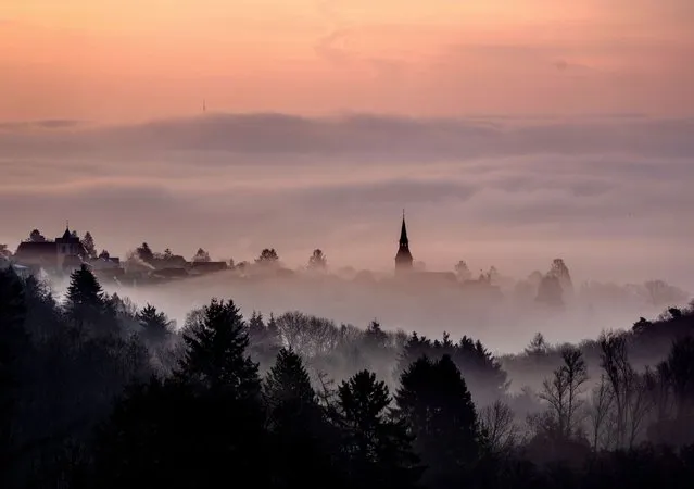 Fog crawls up to the city of Kronberg near Frankfurt, Germany, Wednesday, March 16, 2022. (Photo by Michael Probst/AP Photo)