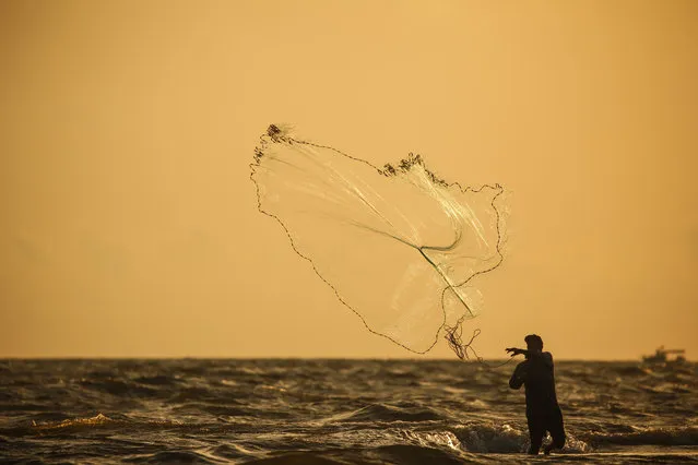 A silhouette of a fisherman is seen as he casts a net to catch fishes in Orontes River at Samandag district in Hatay, Turkey on June 16, 2020. (Photo by Ozan Efeoglu/Anadolu Agency via Getty Images)