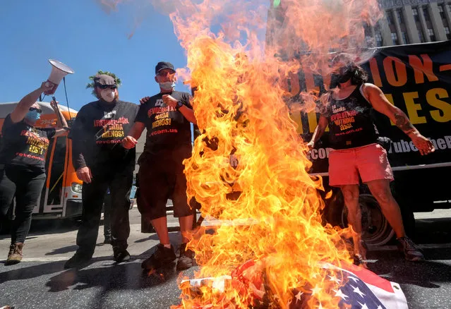 Gregory "Joey" Johnson, 2nd left, whose burning of an American flag in Texas in 1984 led to a U.S. Supreme Court ruling upholding the act as free speech, burns a U.S. flag near Donald Trump's star on the Hollywood Walk of Fame during an anti-Trump rally in in Los Angeles, California, U.S., July 4, 2020. (Photo by Ringo Chiu/Reuters)
