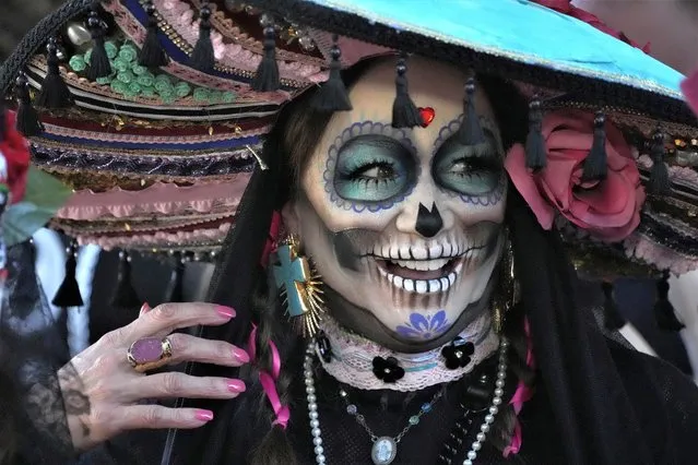 Dressed as a Catrina, a participant prepares to join the Florida Day of the Dead celebration, Saturday, November 5, 2022, in Fort Lauderdale, Fla. (Photo by Wilfredo Lee/AP Photo)