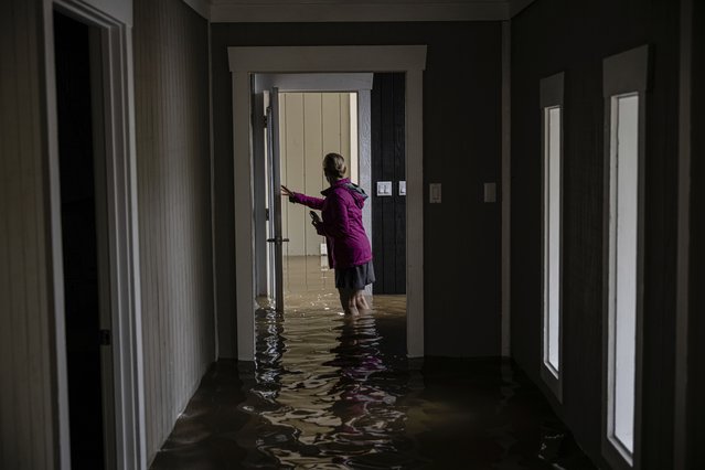 Carole Smith walks through her flooded home in Frankfort, Ky., April 5, 2025. (Photo by Jon Cherry/AP Photo)