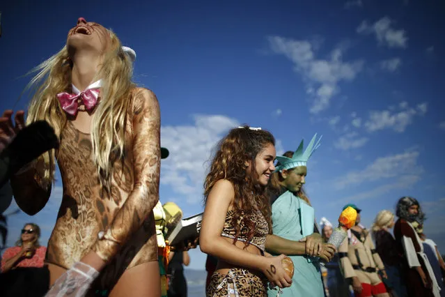 Vienna Werner, 16, (L) and Colby Palacio, 14, (3rd L) wait to compete during the 7th annual ZJ Boarding House Haunted Heats Halloween surf contest. (Photo by Lucy Nicholson/Reuters)