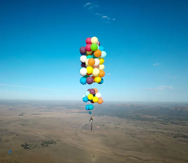Tom Morgan, from Bristol-based company The Adventurists, flies in a chair with large party balloons tied to it near Johannesburg, South Africa, October 20, 2017. (Photo by The Adventurists and Richard Brandon Cox via Reuters)